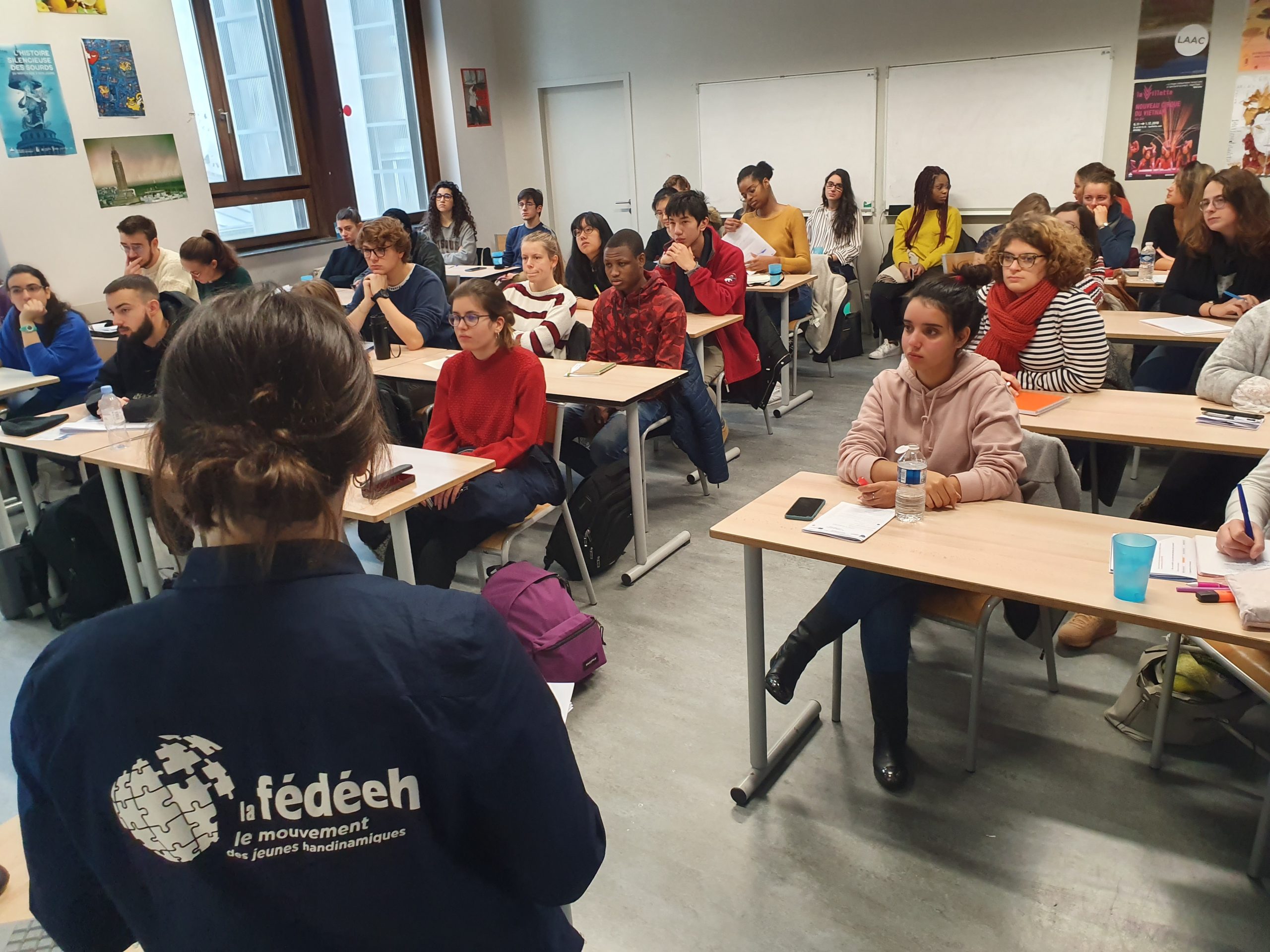 Un groupe lors d'un forum ainsi qu'un membre de l'association qui anime