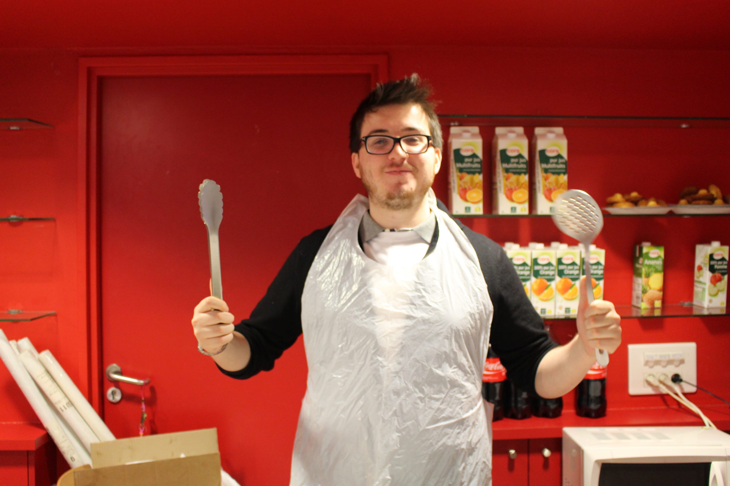 un homme avec des ustensiles de cuisine et un tablier blanc