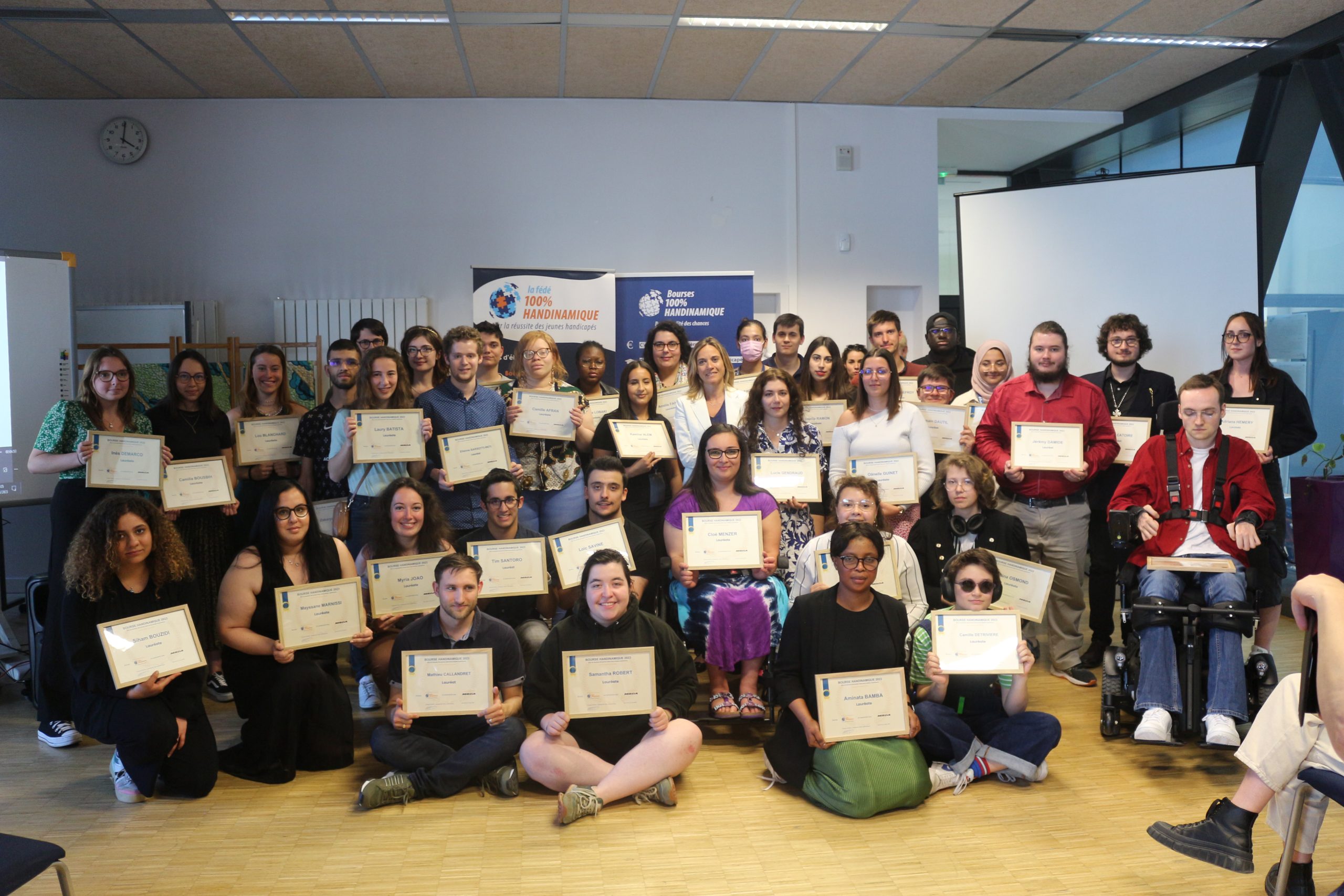 Un groupe de jeunes tenant leur document de bourse obtenue grâce à l'association